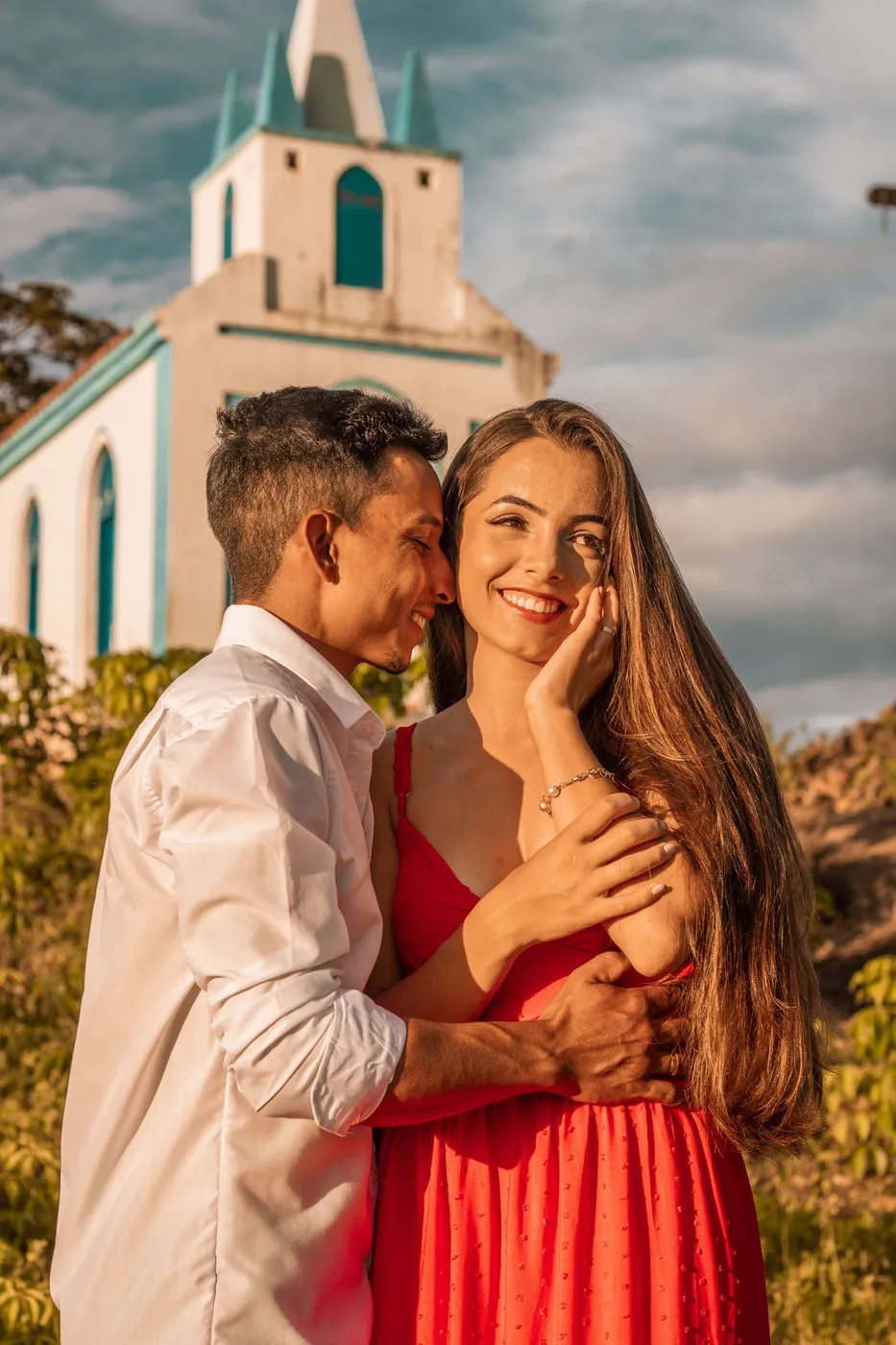Casal abraçado em frente a uma igreja